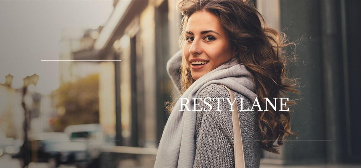 A woman wearing a sweater and scarf with the word restylane in front of her.